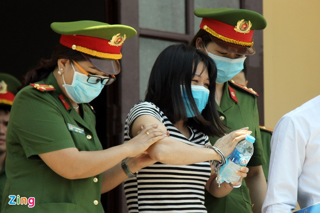 Cảnh sát đưa Nguyễn Thị Thu Loan ra xe đặc chủng sau khi bị cáo tỉnh lại. Ảnh: Hoàng Lam.