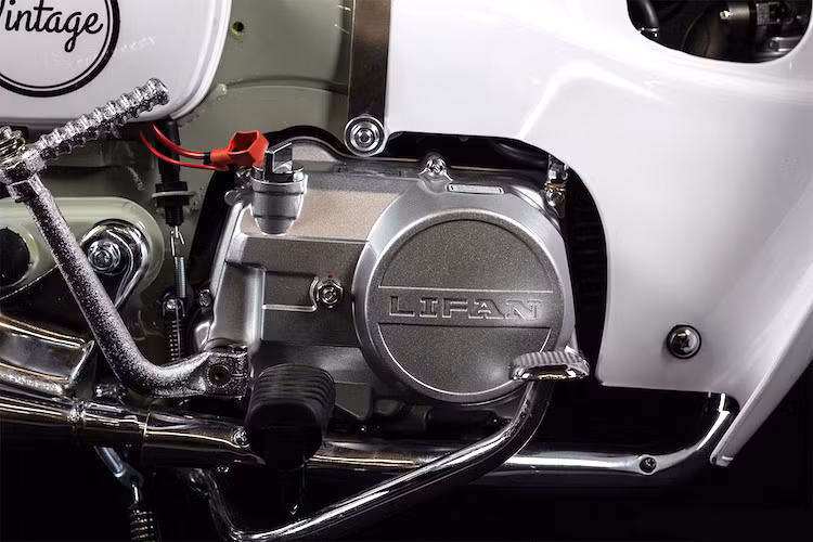 Trong khi đó, bưởng côn của chiếc xe lại có thiết kế giống Honda Dream. Vẫn sử dụng chế hòa khí và có 1 xi-lanh nằm ngang SOHC, động cơ này tạo ra công suất tối đa 8 mã lực. Lifan cũng tích hợp cho Vintage bộ đề để khách hàng không phải đạp nổ như những chiếc Cub đời cũ.