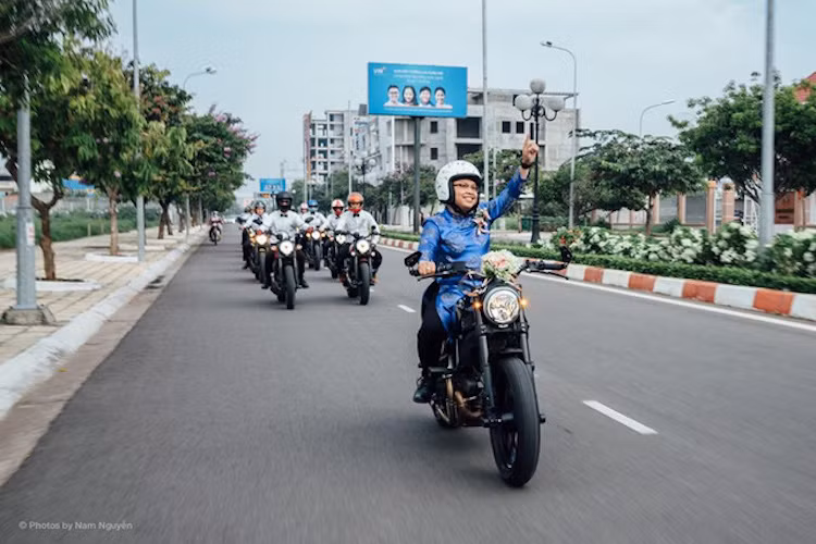 Trong khi đó, chú rể dẫn đầu đoàn trên chiếc Ducati Scrambler màu đen và mặc bộ áo dài màu xanh - lễ phục truyền thống trong đám cưới Việt.