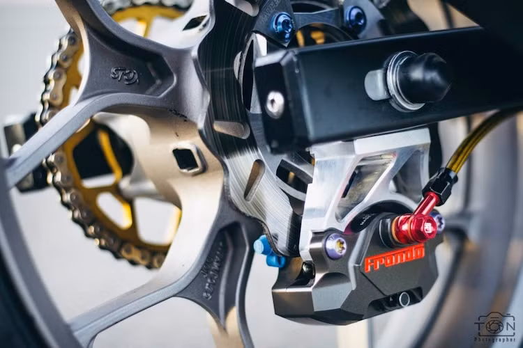 Hệ thống phanh sau cũng đã được nâng cấp đồng bộ với heo Frando 2 pis kèm pát CNC bắt ngược và đĩa Galfer. Thay vì lốp 120/70, chủ xe đã hạ cỡ lốp xuống chỉ còn 100/70/17.