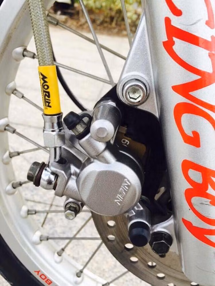 Hệ thống phanh trước của xe đã được nâng cấp lên phanh đĩa từ Honda Wave S 110, trong khi niềng nhôm Racing Boy đã thay cho bộ niềng sắt mạ nguyên bản của mẫu xe số Honda Dream II.