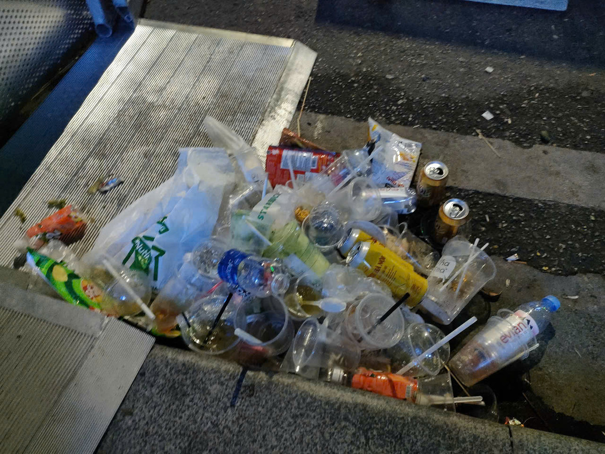 Theo ghi nhận của phóng viên, nhiều tấm giấy để lót chỗ ngồi bị người dân bỏ lại. Cạnh đó là túi nhựa, ly nhựa, chai nhựa, đồ ăn thừa... vứt la liệt trên đất.