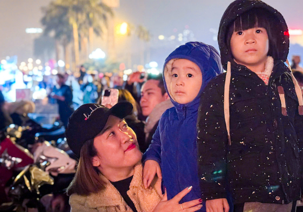 Trẻ em được cha mẹ cho đi xem màn bắn pháo hoa đón chào năm mới 2025.