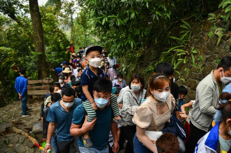 Nhiều ông bố phải cõng con mình lên đầu để đảm bảo an toàn trong lúc di chuyển lên các đền. (Ảnh:Zing.vn)
