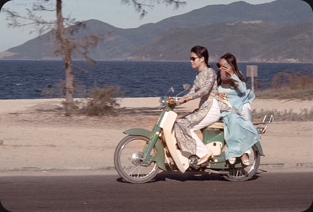 Hai thiếu nữ áo dài trên chiếc Honda Dame C50 màu xanh lá.