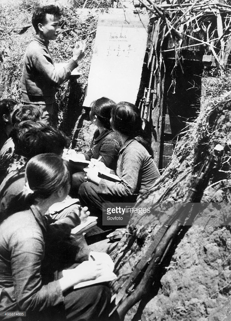 Thầy giáo - chiến sĩ dạy toán cho các đồng đội tại một lớp học ngay dưới chiến hào ở Vĩnh Linh, Quảng Trị năm 1960, một hình ảnh đáng nhớ về nhà giáo Việt Nam thời chiến. Ảnh: Getty Images.