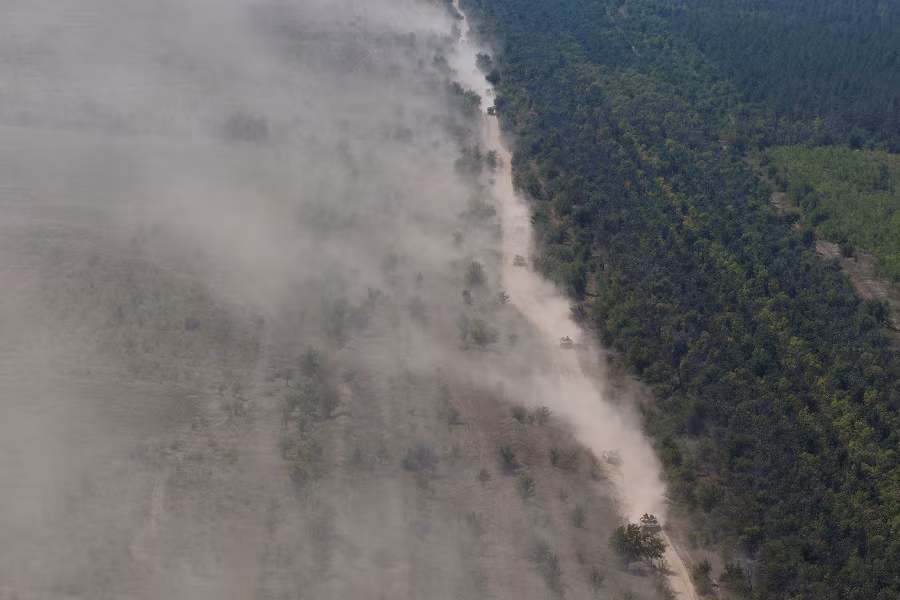 Trong ảnh, đoàn xe bọc thép Quân đội Nga hành quân khiến khói bụi mù mịt.