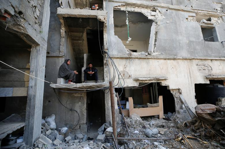 Người dân Palestine ngồi trong ngôi nhà bị hư hại ở Gaza ngày 9/6.