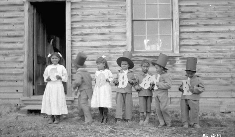 Những em nhỏ cầm chữ cái ghép lại thành từ có nghĩa "Tạm biệt" tại trường nội trú Fort Simpson Indian ở Fort Simpson năm 1922.