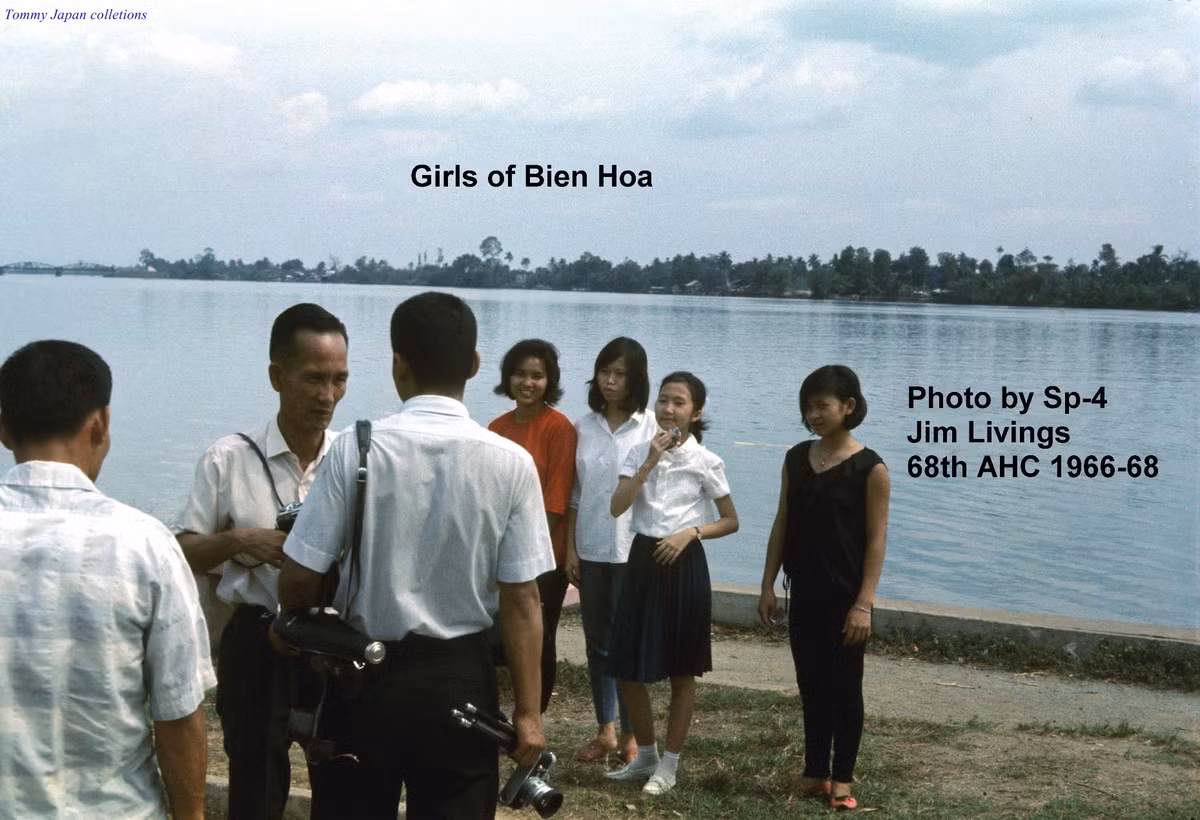 Các thợ ảnh và các thiếu nữ bên bờ kè sông Đồng Nai. Ảnh: Jim Livings.