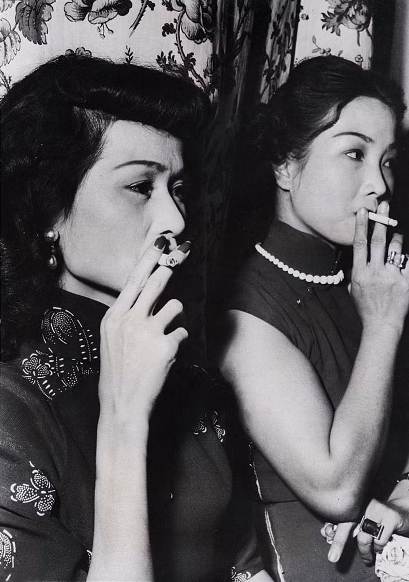 Hai vũ nữ hút thuốc lá trong lúc chờ khách tại một hộp đêm ở Sài Gòn. Ảnh tư liệu.