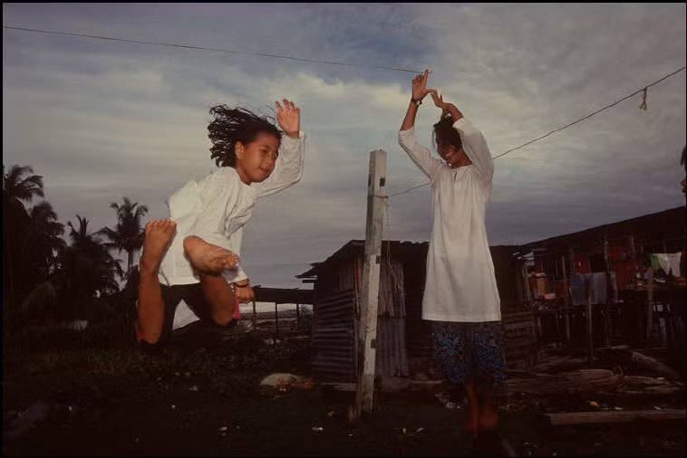 Trẻ em vui chơi gần làng nổi Kampong Ayer. Ảnh: Gueorgui Pinkhassov.