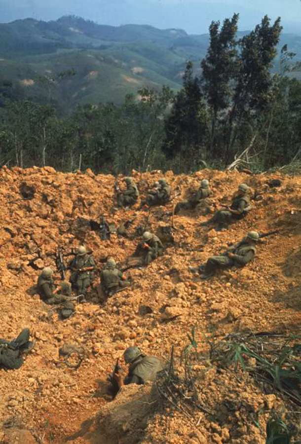Thủy quân lục chiến Mỹ kẹt trên một sườn đồi bị đánh bom nham nhở, đang chờ trực thăng cứu hộ. Ảnh: Larry Burrows.