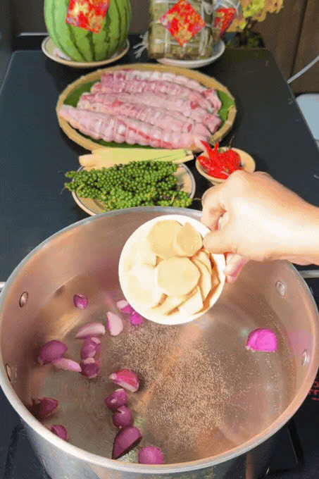 Bắc một nồi nước to lên bếp, thêm hành tím, gừng thái lát và tiêu xanh vào để nồi nước luộc bò thơm. Ảnh kenhcuamy