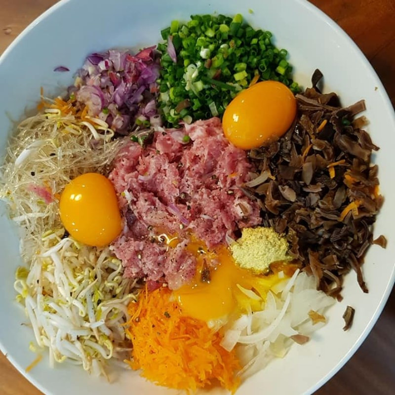  Sơ chế nguyên liệu và làm nhân nem rán: Thịt lợn mua về bạn rửa sạch, rồi băm nhuyễn. Tiếp theo, mang giá đỗ đi rửa sạch, rồi vắt kiệt nước. Cà rốt, hành tây sau khi loại bỏ vỏ và rửa sạch, bạn thái sợi. Hành lá thái nhỏ. Ngâm mộc nhĩ với nước ấm trong vòng 15 phút cho nở mềm, sau đó rửa sạch rồi băm nhỏ. Miến trần nhanh qua nước sôi cho sợi mềm ra, rồi lấy kéo cắt thành đoạn nhỏ. Ảnh minh họa