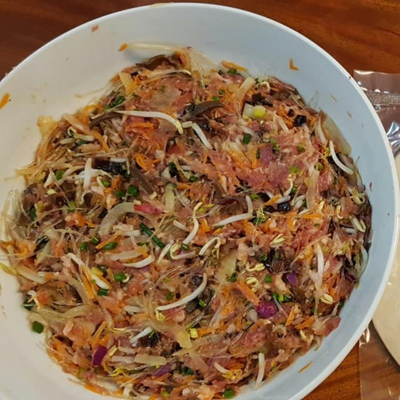 Sau khi sơ chế xong các nguyên liệu, cho hết vào một tô lớn, rồi cho 2 lòng đỏ trứng gà, 2 muỗng cà phê đường, 1 muỗng cà phê hạt nêm, 1 muỗng cà phê tiêu xay vào, trộn đều. Có thể gia giảm gia vị cho phù hợp. Ướp trong 15 phút để phần nhân thấm đều gia vị. Ảnh minh họa