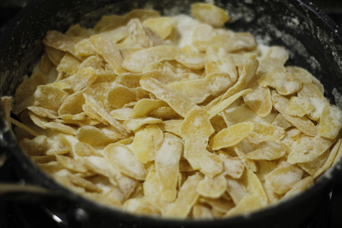 Khi đường cạn sánh thì hạ lửa nhỏ và đảo liên tục đều tay cho tới khi đường kết tinh bám đều các mặt miếng gừng. Ảnh Internet