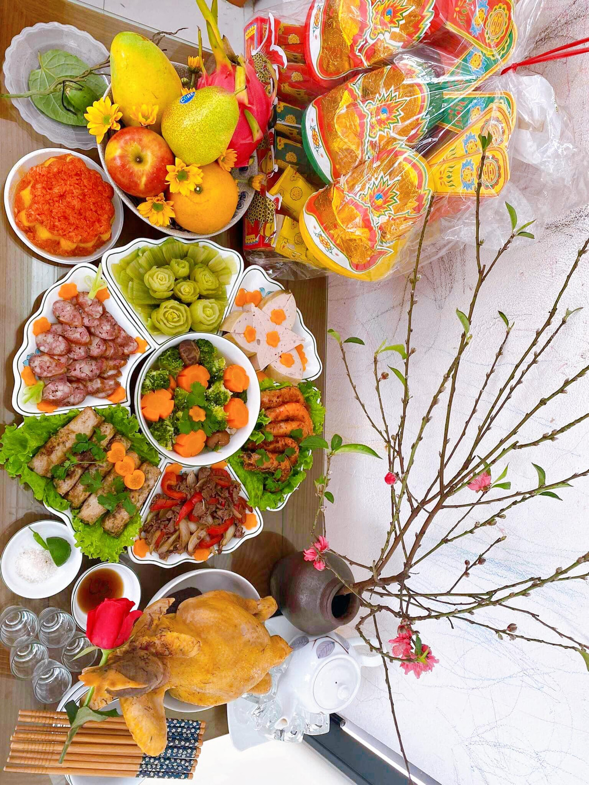 Trước đây, mâm cỗ cúng ông Táo gồm rất nhiều món ăn truyền thống giống các món người dân ăn Tết. Một mâm cỗ mặn đầy đủ thường có: Gà luộc hoặc có thể dùng thịt vai luộc, giò, nem rán, xào thập cẩm, canh (canh bóng, canh măng khô, canh mọc hoặc rau củ hầm…), xôi gấc (hoặc xôi đỗ xanh…), chè kho, hoa quả, một quả bưởi. Ảnh FB Huyền Anh