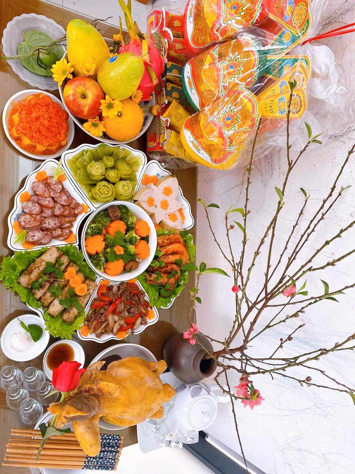 Trước đây, mâm cỗ cúng ông Táo gồm rất nhiều món ăn truyền thống giống các món người dân ăn Tết. Một mâm cỗ mặn đầy đủ thường có: Gà luộc hoặc có thể dùng thịt vai luộc, giò, nem rán, xào thập cẩm, canh (canh bóng, canh măng khô, canh mọc hoặc rau củ hầm…), xôi gấc (hoặc xôi đỗ xanh…), chè kho, hoa quả, một quả bưởi. Ảnh FB Huyền Anh