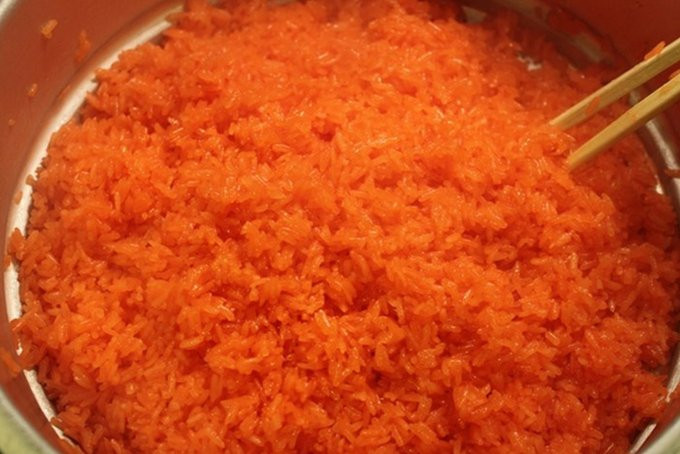 Để có đĩa xôi gấc ngon căng mẩy, bóng mượt cần đồ 2 lần lửa. Lần 1: Đun sôi nước, làm nóng chõ đồ xôi, hạ nhiệt và cho gạo nếp vào chõ, dàn đều. Sau 20 - 30 phút khi xôi chín được 80% thì dỡ ra giá, dàn đều. Cho 100 gr đường (điều chỉnh theo khẩu vị), chút dầu ăn vào xôi rồi đảo đều. Ảnh minh họa