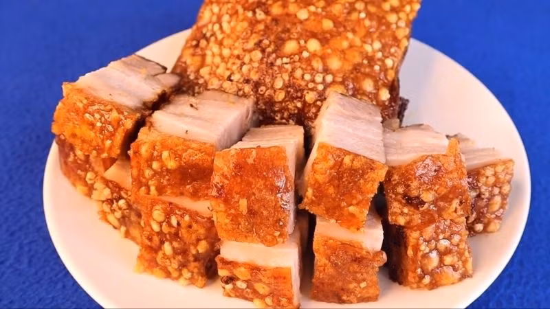 Dùng 1 miếng giấy bạc lót dưới nồi để mỡ chảy ra không bị khô và làm gỉ nồi. Cho thịt vào nồi chiên, chú ý để phần da lên phía trên. Chỉnh nhiệt độ 180 độ C và nướng trong 60 phút. Sau đó, lấy thịt ra và cắt thành những miếng vừa ăn. Ảnh Internet