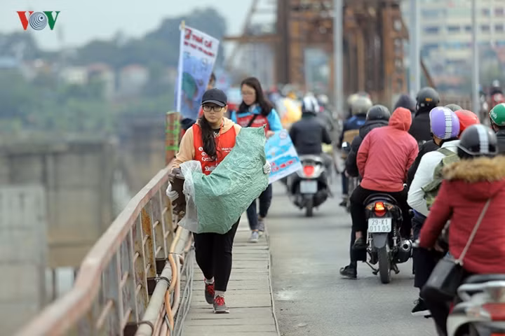 Nhóm học sinh, sinh viên tình nguyện giúp người dân xử lý bàn thờ vất đi tránh tình trạng ném xuống sông Hồng.