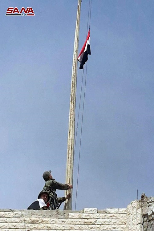 Hình ảnh quốc kỳ Syria được kéo lên bên trong một trong những trụ sở chính quyền tại Erbin, Đông Ghouta. Ảnh: Sana.