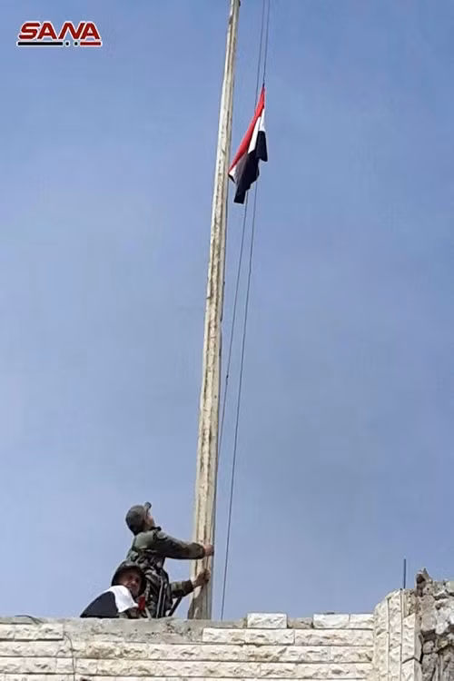 Hình ảnh quốc kỳ Syria được kéo lên bên trong một trong những trụ sở chính quyền tại Erbin, Đông Ghouta. Ảnh: Sana.