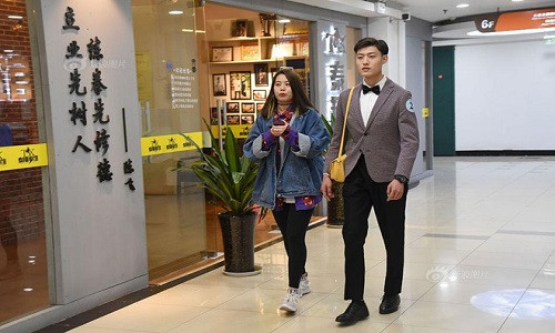 "Bạn trai chia sẻ" sẽ cầm túi, chụp ảnh, trò chuyện ... cùng khách hàng khi họ đi mua sắm. Ảnh: Sina.