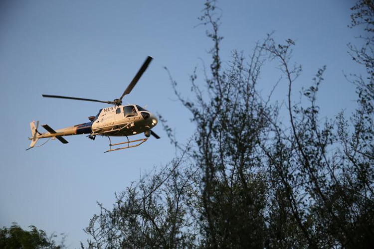 Trực thăng của biên phòng Mỹ đóng vai trò trinh sát, chỉ điểm hoạt động của các nhóm vượt biên cho lực lượng bên dưới mặt đất trong một chiến dịch truy bắt các di dân vượt biên trái phép vào Mỹ. Ảnh: Reuters.