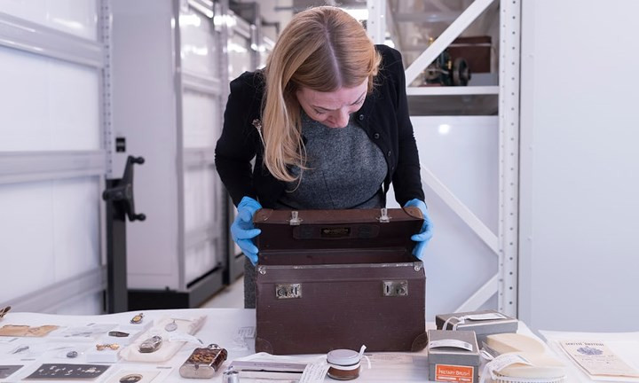 Giám tuyển cao cấp của Bảo tàng Melbourne Deborah Tout-Smith xem xét chiếc túi da của ông Ward.