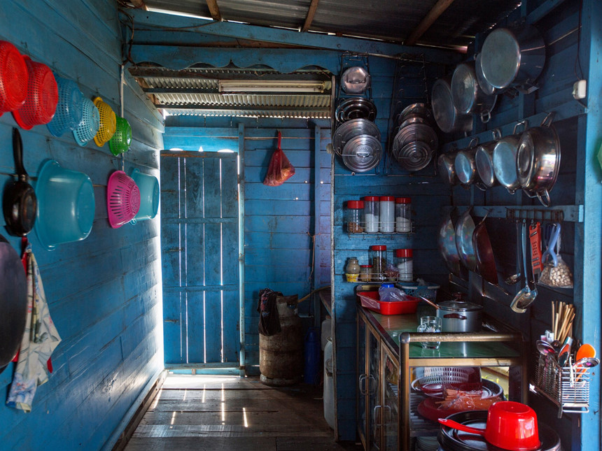 Đây là một gian bếp, trông rất bình thường trừ việc nó nằm trên mặt nước, chính xác là nằm trên Biển Hồ, Campuchia. Như mọi căn nhà khác ở đây, nó đối mặt với hàng loạt nguy cơ mà dòng nước mang lại, đặc biệt trong mùa mưa. Vào cuối tháng 7, lúc nào cũng có việc cho Taing Hoarith làm với ngôi nhà của ông. Khi thì ông phải sửa lại bức tường lợp bằng lá cọ đã bị bão làm hư, khi thì ông phải dọn dẹp đám cây mọc trong nước. Đôi khi ông phải lặn xuống bên dưới căn nhà, miệng ngậm một ống cao su và chèn vào những hũ xi măng đang giữ căn nhà đứng vững trên nước. Ảnh: New York Times.