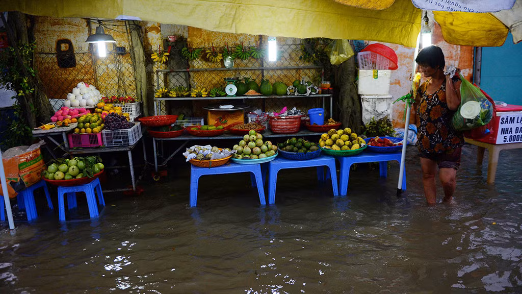 Một quầy bán trái cây phải kê lên tránh nước - Ảnh: HỮU KHOA