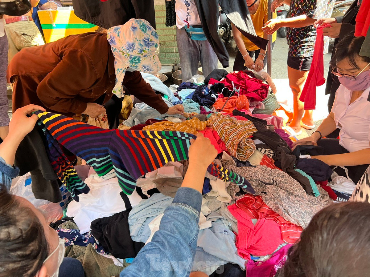 Quần áo được chất đống trên tấm bạt trải ngay mặt đường, khách có thể ngồi hàng giờ liền để xới tung đống đồ, chọn những chiếc áo quần thấy vừa mắt. Người bán cũng không nề hà chuyện phụ khách tìm hàng ưng ý và luôn tay đảo trộn quần áo từ dưới lên để khách dễ dàng tìm kiếm.