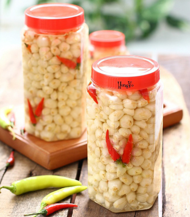 Kiệu sau khi sơ chế xếp vào hũ, rồi từ từ đổ hỗn hợp đường phèn và giấm vào và đậy kín nắp lại. Ảnh: cachnauan.