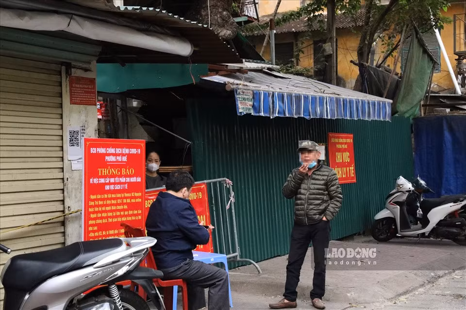 Dù có biển thông báo của Ban chỉ đạo phòng chống dịch phường Phố Huế nhưng người dân vẫn lơ là khi bỏ khẩu trang hút thuốc lá và không đảm bảo khoảng cách an toàn.