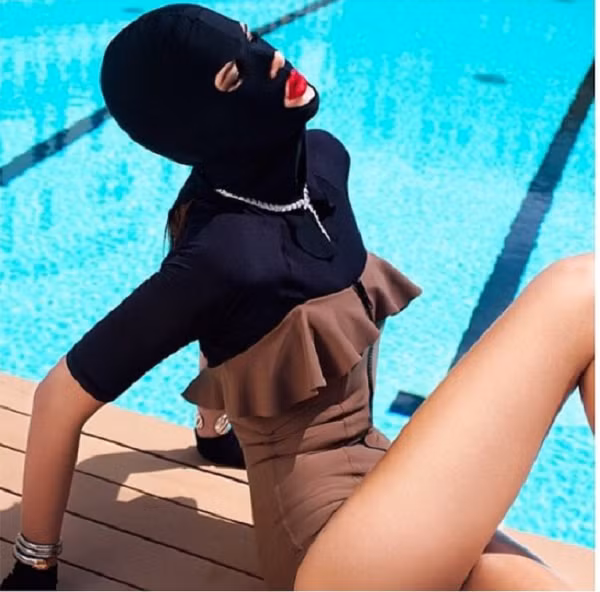Lớp vải che mặt trong hình được gọi là “facekini”. Mục đích của chúng nhằm bảo vệ da khỏi tác hại của ánh nắng mặt trời. Tuy nhiên, vẻ ngoài của chúng có phần “dọa người”, hiếm ai đủ can đảm sử dụng giữa đám đông.