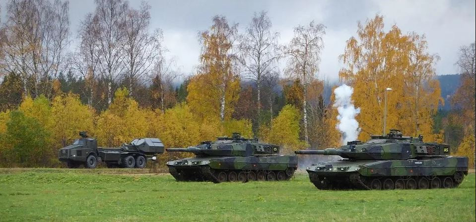 Ngoài ra, để sử dụng Strv 122 ở nước ngoài với tư cách là thành viên của các nhóm quốc tế, nó đã được nâng cấp các phương tiện liên lạc và hệ thống chỉ huy mới tương thích với NATO. Strv 122 cũng được sửa đổi để sử dụng ở vùng có khí hậu nóng.