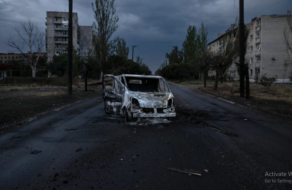 Binh lính Ukraine này ngồi trên chiếc giường cũ nát trong một boongke dưới tầng hầm với ánh sáng yếu ớt từ màn hình video, cách quân Nga hơn 1km. Bên ngoài, những khung kim loại bị cháy xém và cong vênh của ít nhất 4 chiếc xe nằm rải rác bên lề đường khi cố thoát ra khỏi thành phố, nhắc nhở rằng bất kỳ chuyển động nào của họ cũng có thể đối mặt với nguy hiểm chết người. (Nguồn ảnh: NYT, TASS, Ukrinform).