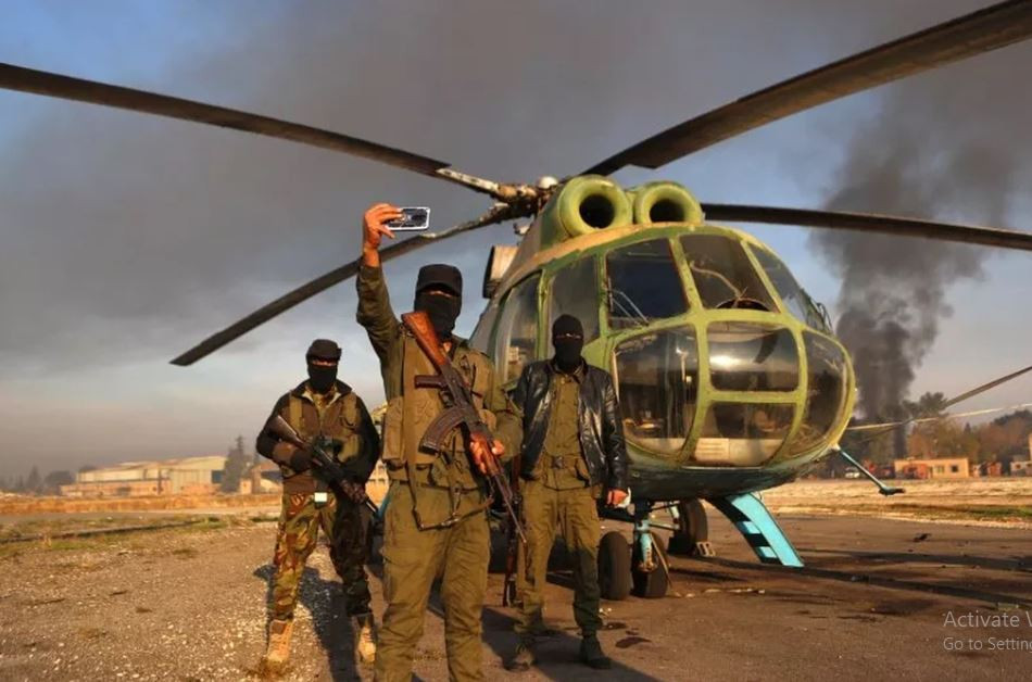 Sau khi các đơn vị của Quân đội Chính phủ Syria bị quân HTS xâm nhập và chia cắt ở ngoại ô Aleppo và trong thành phố, họ đã đầu hàng mà không gặp phải sự kháng cự cơ bản nhất nào. Họ cũng “biếu không” một số lượng lớn xe tăng và xe bọc thép cho phiến quân khủng bố. Ảnh: Quân nổi dậy chiếm giữ sân bay và thu giữ trực thăng của Quân đội Chính phủ Syria. 