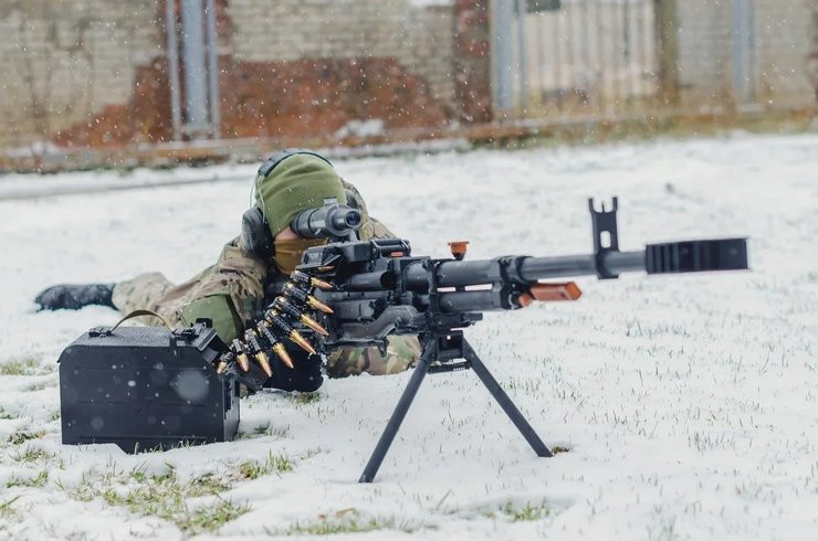 Để thiết kế mẫu súng máy hạng nặng mới này, một điều thuận lợi với các thợ súng Kovrov là họ không phải bắt đầu từ con số 0, mà được kế thừa một bản thiết kế súng máy hạng nặng 12,7 mm có từ năm 1987; nhưng do sự tan rã của Liên Xô nên chương trình đã bị trì hoãn.