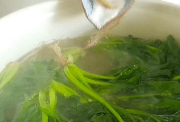 Đầu tiên, chúng ta rửa sạch rau mồng tơi, sau đó chuẩn bị một nồi nước 300ml, đổ rau mồng tơi vào, đậy nắp và chần trong 3 phút, vớt ra, sau khi để nguội thì cắt bỏ rễ và thái nhỏ