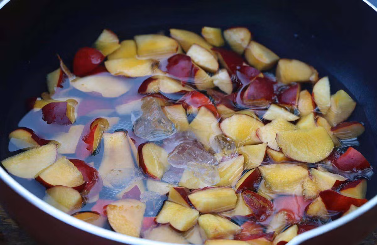 Bước 3: Cho đào vào nồi chống dính, đổ thêm nước, cho thêm đường phèn.