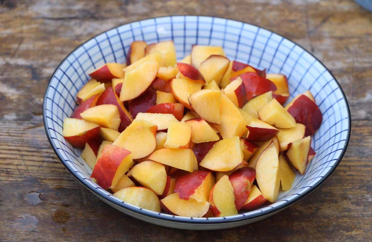 Bước 2: Bổ tách bỏ hạt đào, tách cùi và thái thành từng miếng nhỏ.