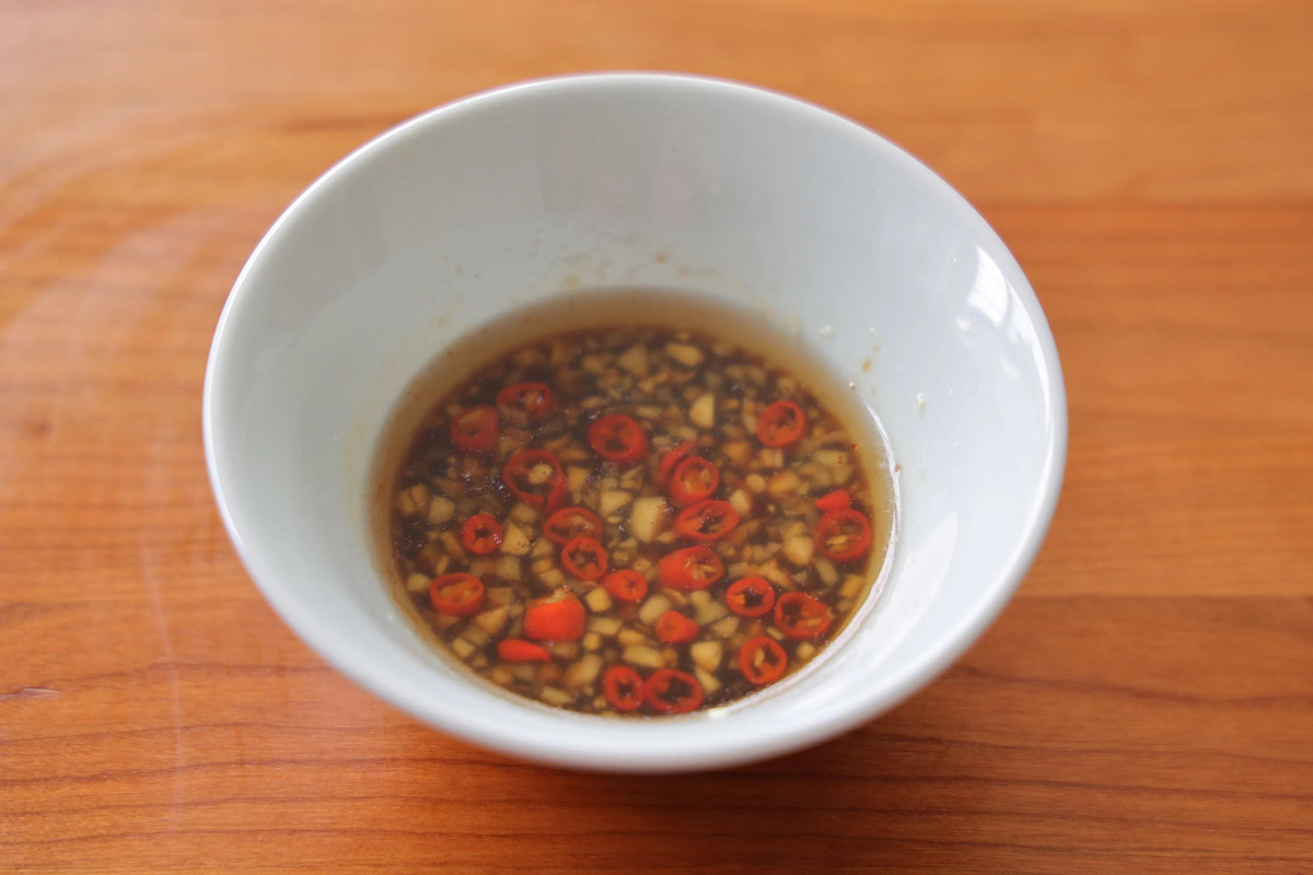 Bước 5: Băm nhỏ tỏi, ớt cho chung vào một bát, thêm chút hoa hồi vừa đủ. Đun dầu nóng rồi đổ vào bát đựng tỏi và ớt. Sau đó cho thêm tương nhạt, dấm, bột canh, đường vào trộn đều làm nước sốt.