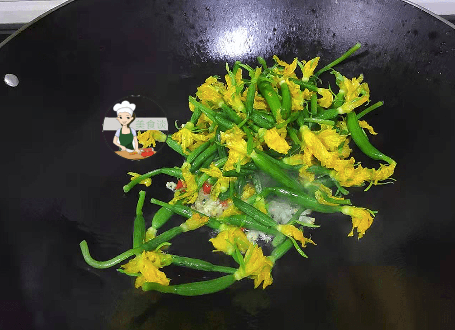 Cho hoa dưa chuột vào xào không thêm nước, đảo liên tục cho đến khi chín tới, cuối cùng nêm chút muối vừa miệng, rưới chút tinh chất gà cho thêm vị, xào đều tay.