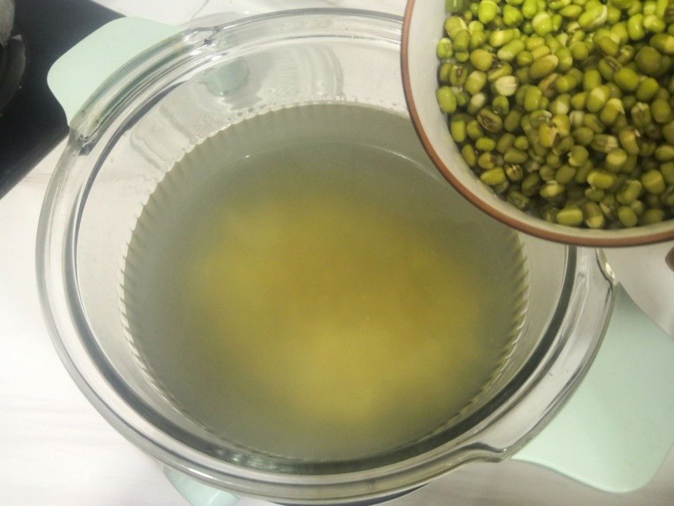 Khi nếm thấy hạt ý dĩ đã mềm thì đổ thêm đậu xanh vào, đậy nắp lại và nấu trong 20 phút cho đến khi đậu chín hoàn toàn.