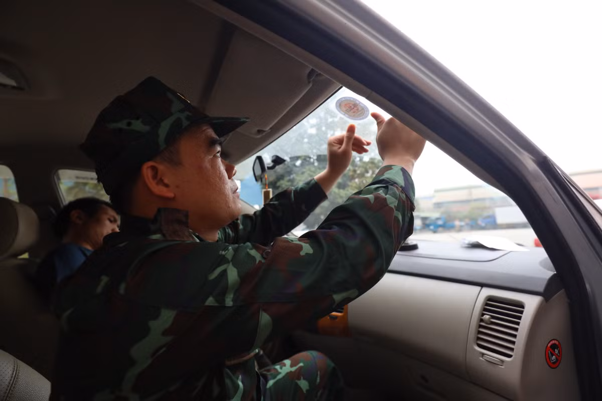 Kiểm định viên quân sự tham gia bước cuối của đăng kiểm xe là dán tem.