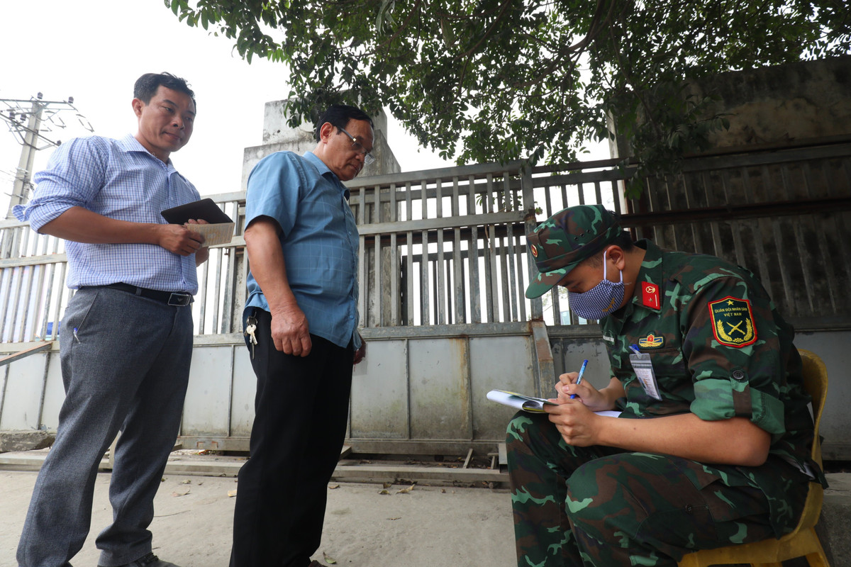 Ngay phía ngoài cổng Trung tâm Đăng kiểm 29-11D, một kiểm định viên quân sự đang ghi chép danh sách các xe đến đăng ký lịch hẹn đăng kiểm và phát phiếu hẹn cho người dân.