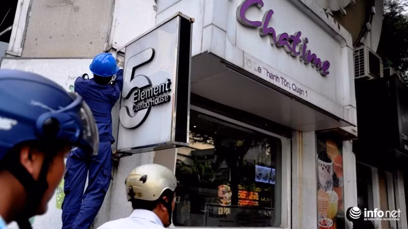 Một bảng hiệu trên cao bị tháo bỏ vì đua ra vỉa hè.